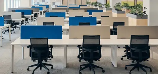 Modern open-plan office space featuring clean workstations, ergonomic chairs, and sanitized carpets provided by professional office cleaning services in Ann Arbor, MI.